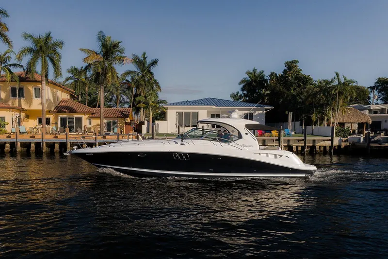 Slide: The Image of 2008 Sea Ray 440 Sundancer yacht cruising near waterfront homes and palm trees. - 3