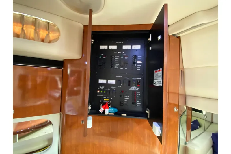 Slide: The Image of Electrical panel inside 2004 Sea Ray 380 Sundancer yacht, featuring wood cabinetry and modern controls. - 14