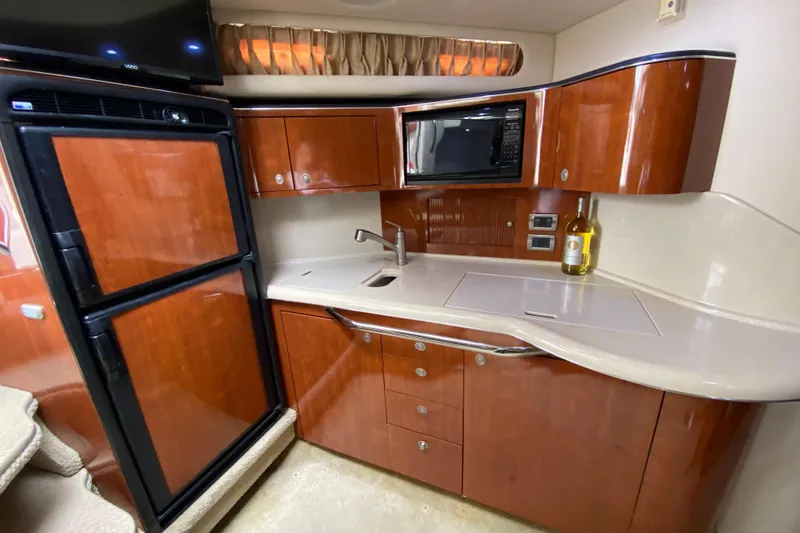 Slide: The Image of Luxurious 2004 Sea Ray 380 Sundancer yacht kitchen with wood cabinetry and modern appliances. - 17