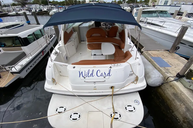 Slide: The Image of 2004 Sea Ray 380 Sundancer docked, featuring "Wild Card" name and spacious seating area. - 3