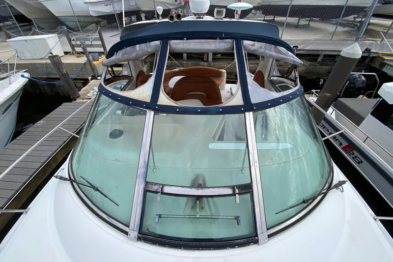 Slide: The Image of 2004 Sea Ray 380 Sundancer docked, showcasing sleek windshield and cockpit design. - 4