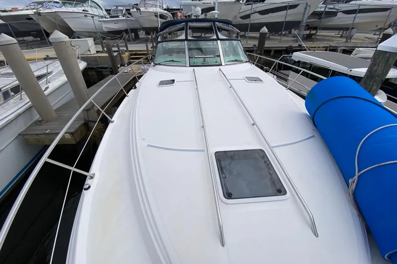 Slide: The Image of 2004 Sea Ray 380 Sundancer yacht docked, featuring sleek white deck and blue fender. - 5
