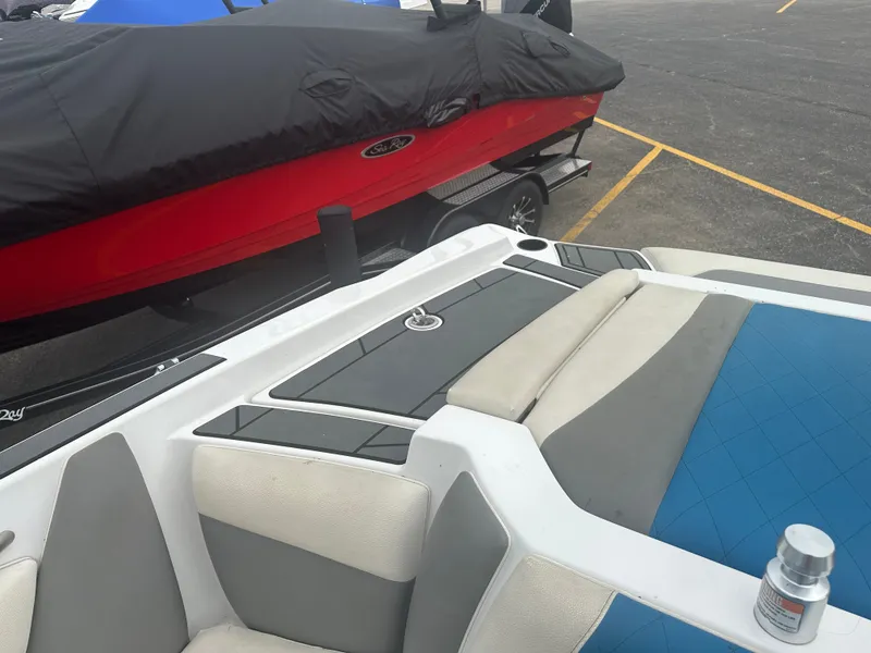 Slide: The Image of 2016 Tigé R20 boat with blue and gray interior, parked next to a covered boat. - 10
