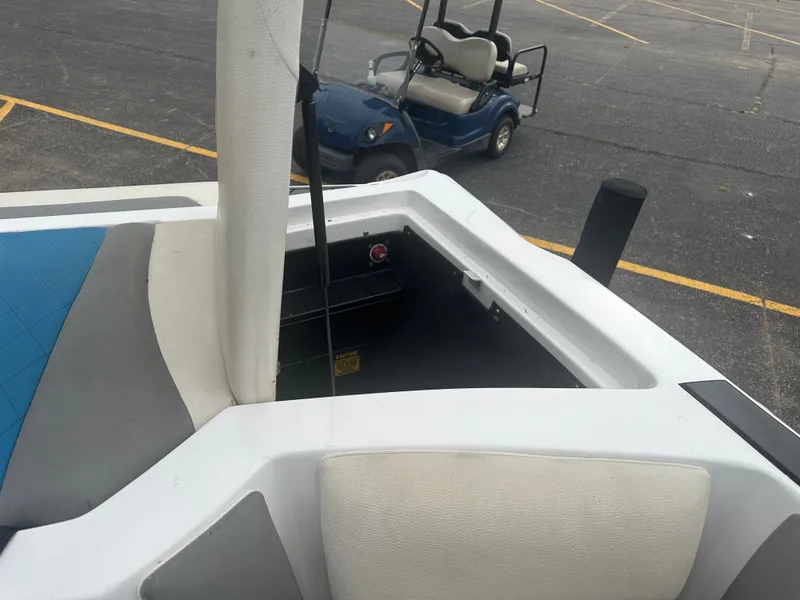 Slide: The Image of 2016 Tigé R20 boat with open storage compartment and golf cart in background. - 25