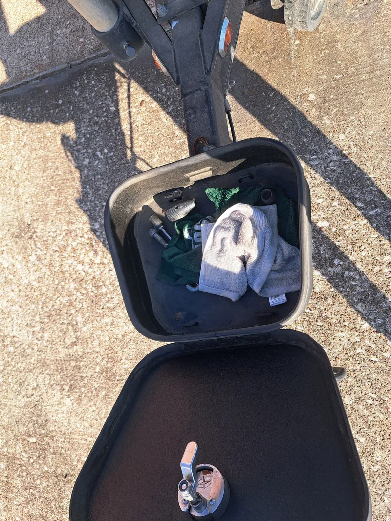 Slide: The Image of Open storage compartment of 2014 Skeeter FX21 with tools and cloths. - 35