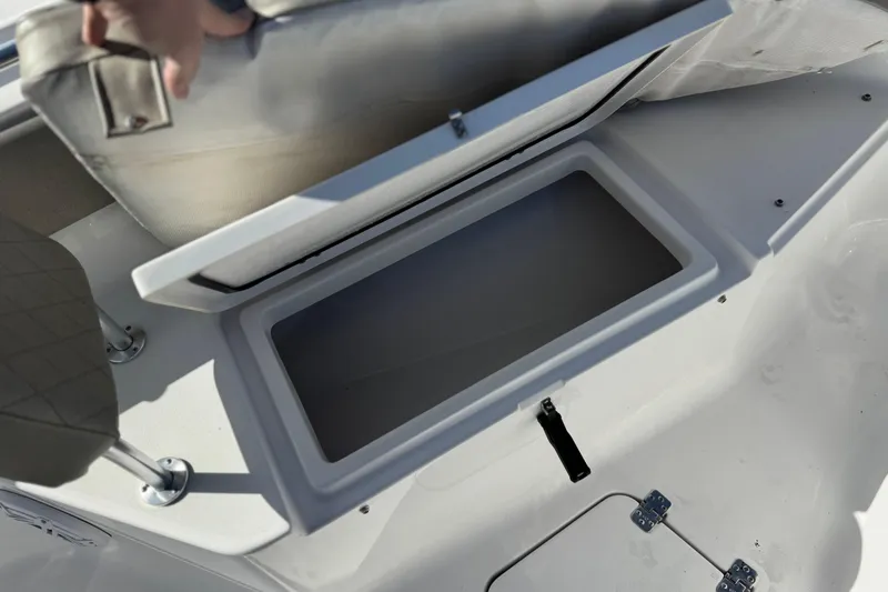 Slide: The Image of 2022 Sportsman Open 212 Center Console boat storage compartment with open lid. - 14