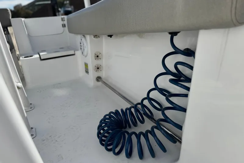 Slide: The Image of 2022 Sportsman Open 212 Center Console interior with coiled blue hose and seating. - 21