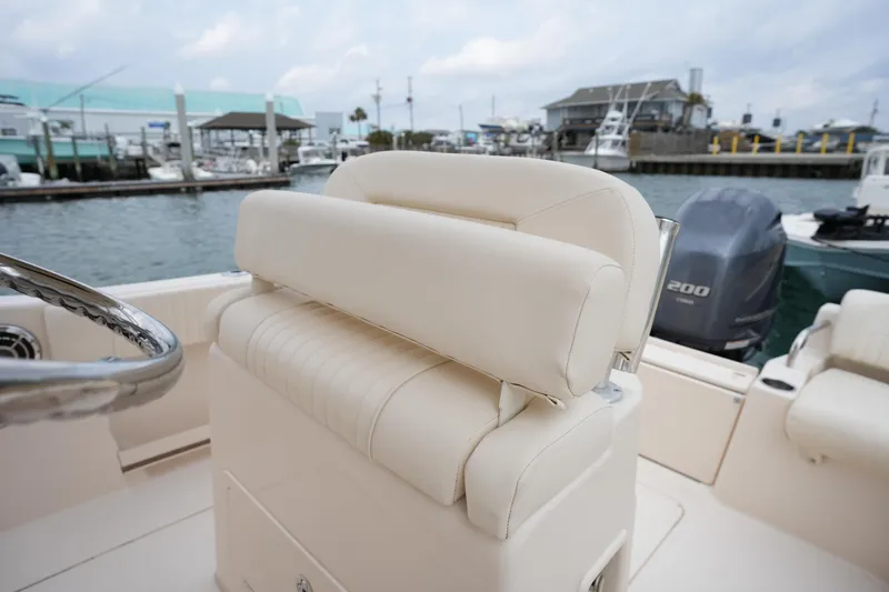 Slide: The Image of 2014 Grady-White Fisherman 209 boat interior with helm seat and marina background. - 17