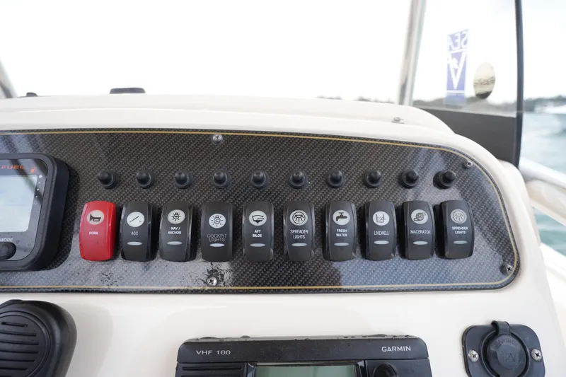Slide: The Image of Control panel of 2014 Grady-White Fisherman 209 boat with labeled switches and Garmin device. - 25