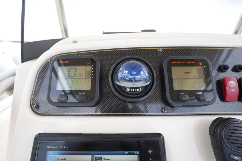 Slide: The Image of 2014 Grady-White Fisherman 209 dashboard with tachometer, compass, and speed fuel gauge. - 26