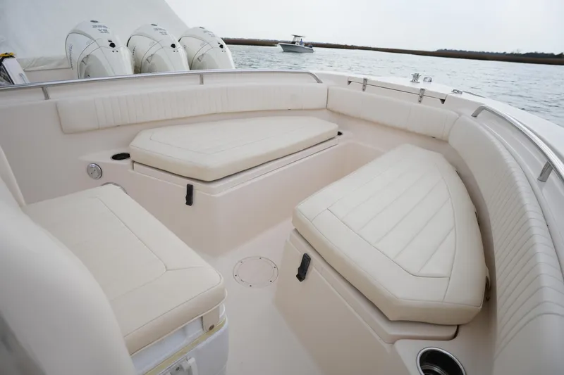 Slide: The Image of 2014 Grady-White Fisherman 209 boat interior with cushioned seating and triple outboard motors. - 32