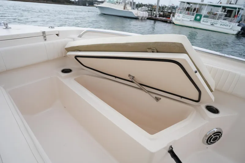 Slide: The Image of 2014 Grady-White Fisherman 209 boat storage compartment open, docked by the water. - 33