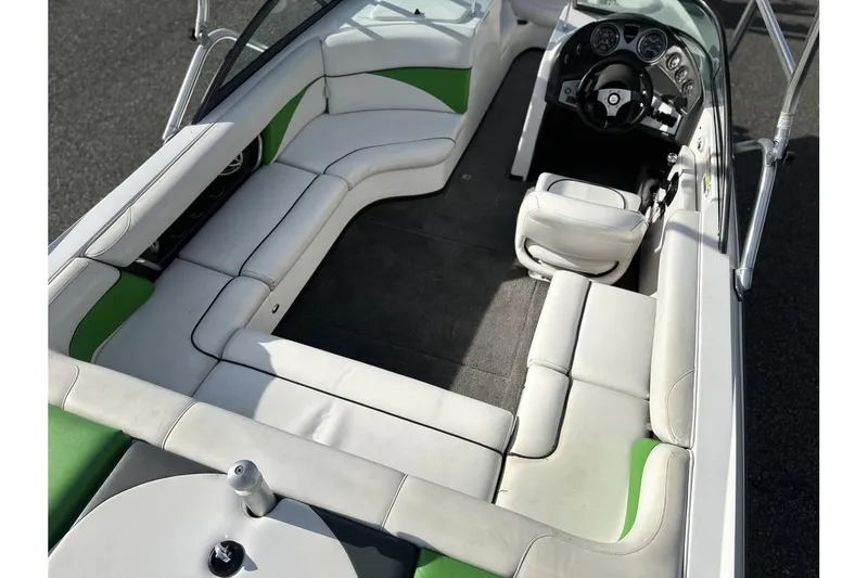 Slide: The Image of 2009 Moomba Outback V boat interior with white and green seating, steering wheel, and dashboard. - 3