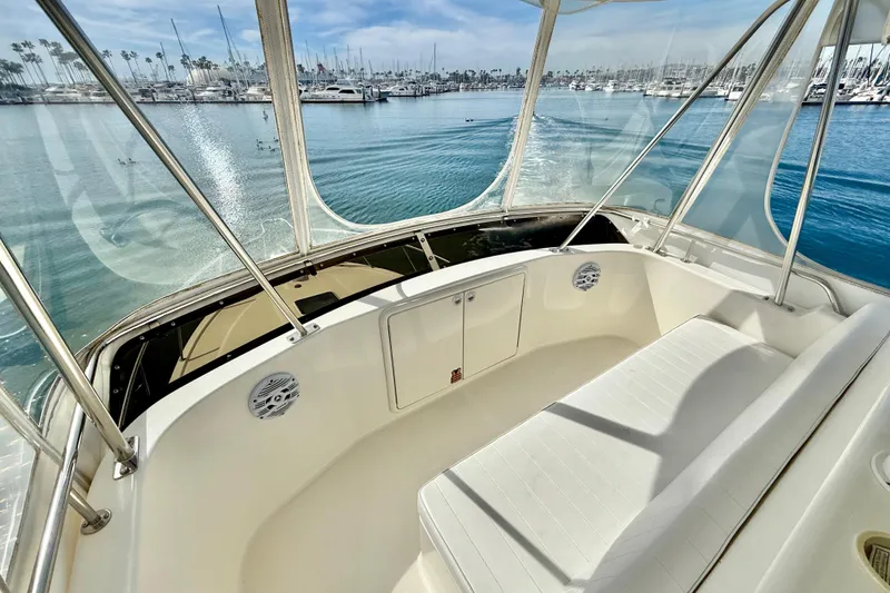 Slide: The Image of 1998 Riviera 34 Convertible boat interior with marina view, featuring white seating and clear windows. - 11