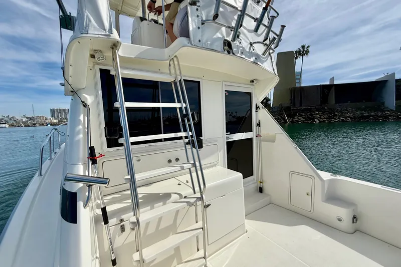 Slide: The Image of 1998 Riviera 34 Convertible yacht with ladder, docked in a marina under blue skies. - 13
