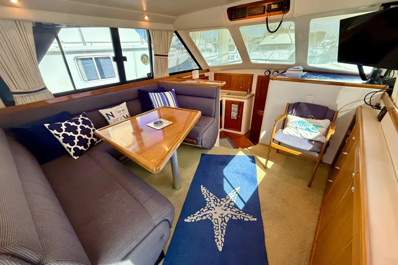Slide: The Image of Interior of 1998 Riviera 34 Convertible yacht with cozy seating and nautical decor. - 16
