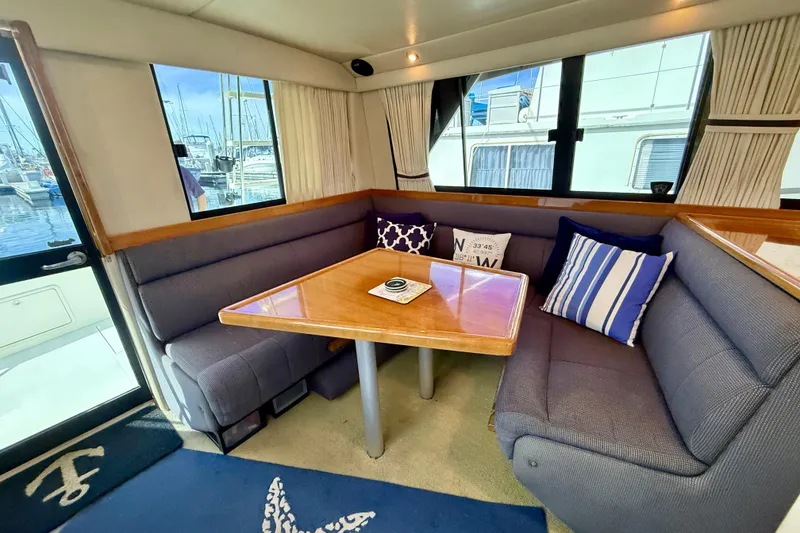 Slide: The Image of Cozy interior of 1998 Riviera 34 Convertible yacht with plush seating and nautical decor. - 17