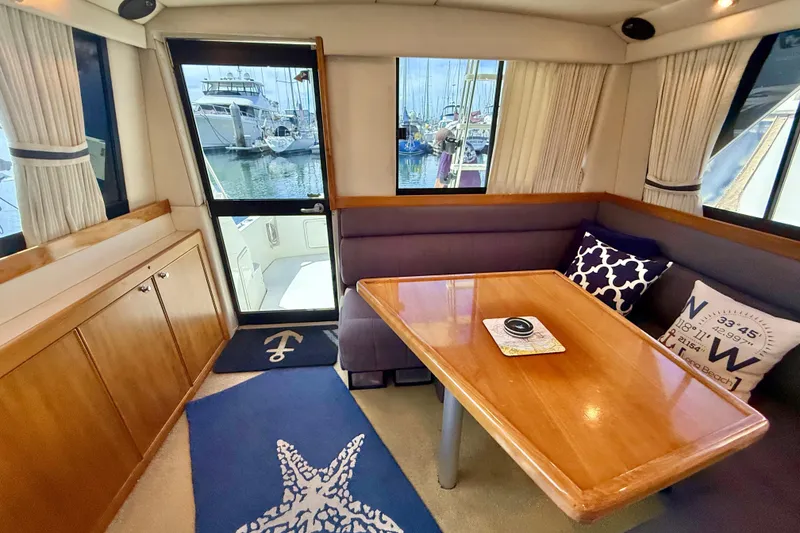 Slide: The Image of Interior of 1998 Riviera 34 Convertible yacht with dining area and marina view. - 18