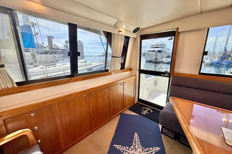 Slide: The Image of Interior of 1998 Riviera 34 Convertible yacht with wooden cabinetry and marina view. - 19