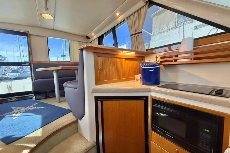 Slide: The Image of Interior of 1998 Riviera 34 Convertible yacht with kitchen and dining area. - 20