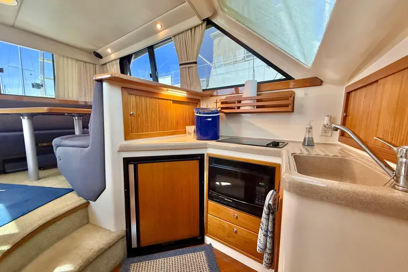 Slide: The Image of Interior of 1998 Riviera 34 Convertible yacht with kitchenette and seating area. - 21