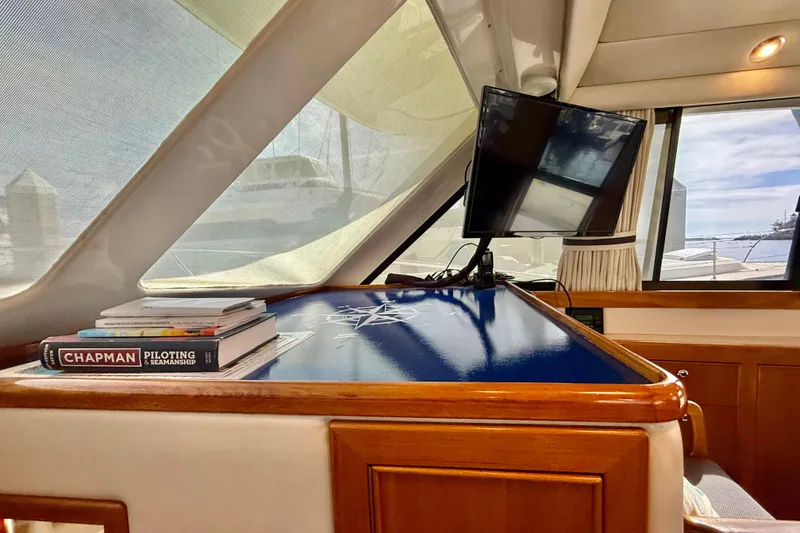 Slide: The Image of Interior of 1998 Riviera 34 Convertible yacht with navigation books and a mounted screen. - 23