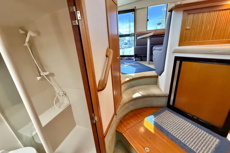 Slide: The Image of Interior of 1998 Riviera 34 Convertible yacht, featuring shower and cabin steps. - 26