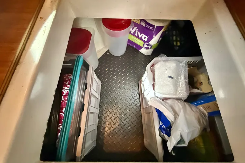 Slide: The Image of Storage compartment in a 1998 Riviera 34 Convertible, containing various household items and supplies. - 30