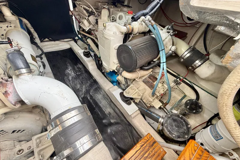 Slide: The Image of Engine room of a 1998 Riviera 34 Convertible boat, showcasing mechanical components and piping. - 36