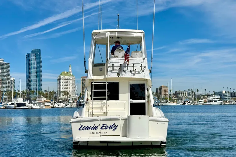Slide: The Image of 1998 Riviera 34 Convertible boat in marina, Long Beach, CA, with city skyline. - 4