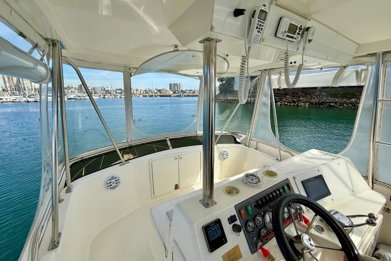 Slide: The Image of Cockpit view of 1998 Riviera 34 Convertible yacht with marina backdrop. - 8