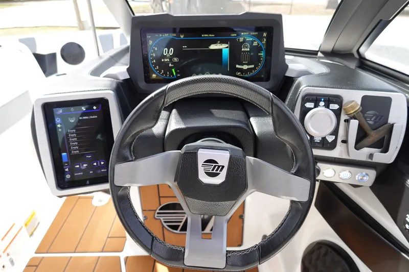 Slide: The Image of 2022 Malibu Wakesetter 23 MXZ dashboard with steering wheel and digital displays. - 12