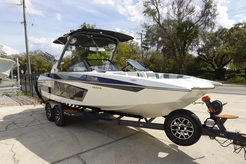 Slide: The Image of 2022 Malibu Wakesetter 23 MXZ boat on trailer, parked outdoors. - 2
