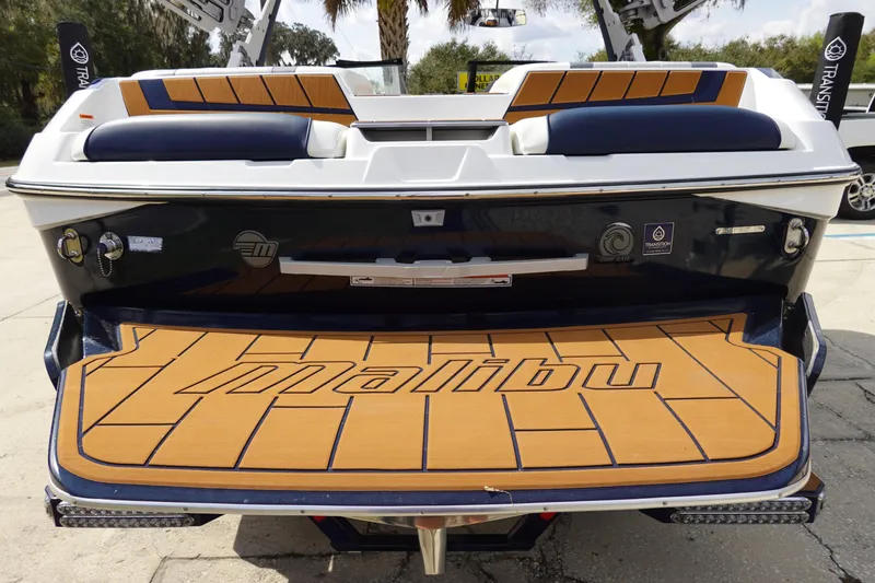 Slide: The Image of 2022 Malibu Wakesetter 23 MXZ boat with teak deck and cushioned seating. - 4