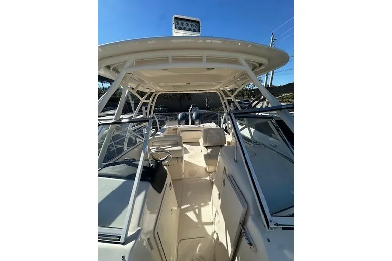 Slide: The Image of 2018 Grady-White Freedom 255 boat interior with seating and steering wheel under a clear sky. - 10