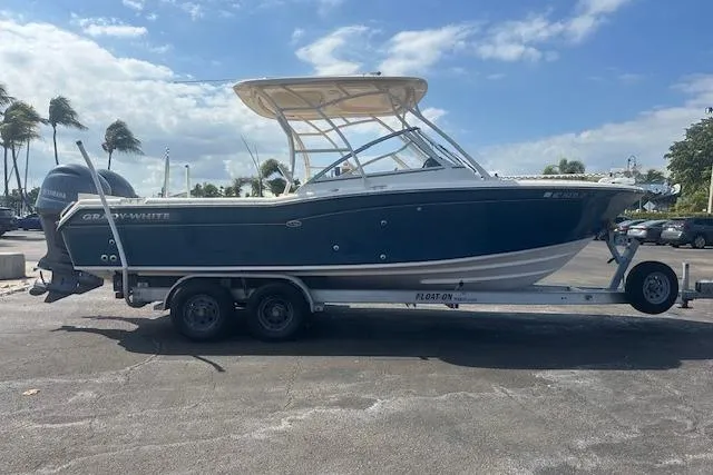 Slide: The Image of 2018 Grady-White Freedom 255 boat on trailer, parked outdoors under a partly cloudy sky. - 8