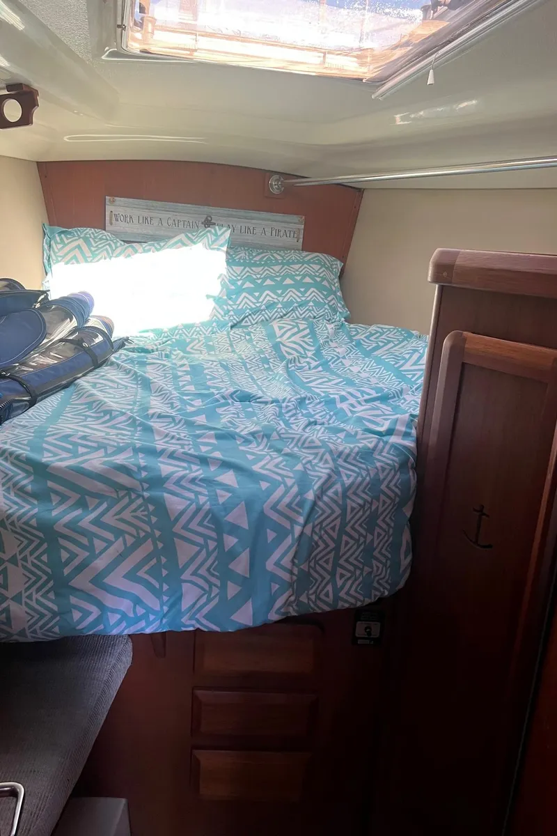 Slide: The Image of 1992 Hunter 43 sailboat cabin with patterned bedding and natural light. - 22