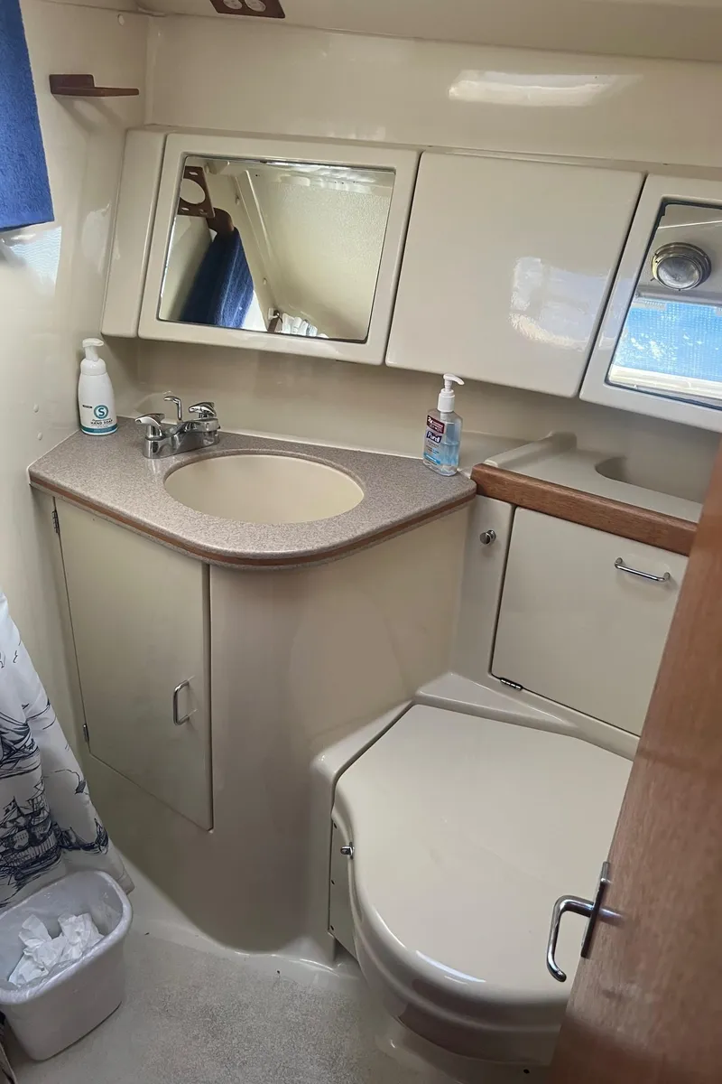 Slide: The Image of Compact bathroom in a 1992 Hunter 43 sailboat with sink, toilet, and storage cabinets. - 24