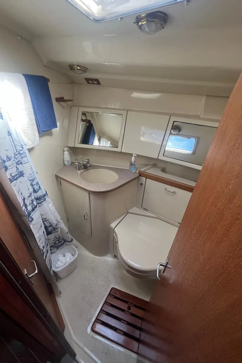 Slide: The Image of 1992 Hunter 43 yacht bathroom with sink, toilet, and nautical-themed decor. - 25