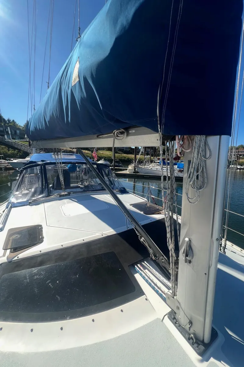 Slide: The Image of 1992 Hunter 43 sailboat with blue sail cover, docked in a sunny marina. - 32