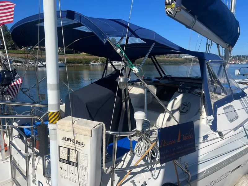 Slide: The Image of 1992 Hunter 43 sailboat docked, featuring a blue canopy and American flag. - 36