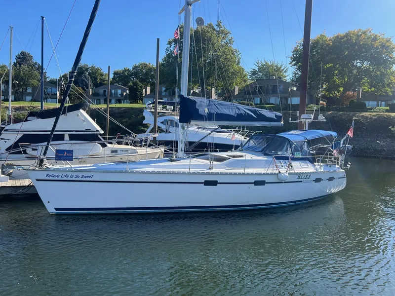 Slide: The Image of Sailboat docked in marina, 1992 Hunter 43 model, with blue canopy and calm water. - 45