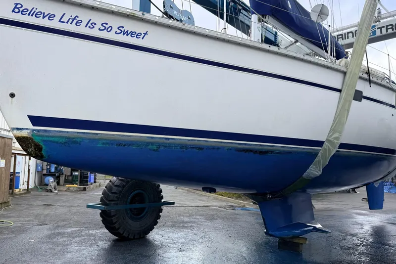 Slide: The Image of 1992 Hunter Legend 43 sailboat on land, displaying "Believe Life Is So Sweet" text. - 49