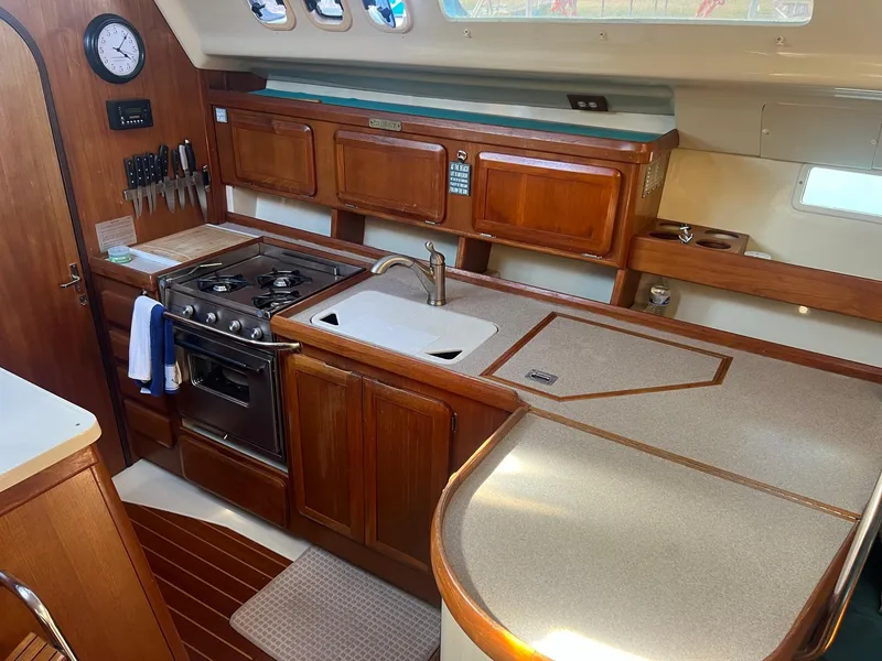 Slide: The Image of Interior of 1992 Hunter 43 sailboat kitchen with wooden cabinets and stove. - 6