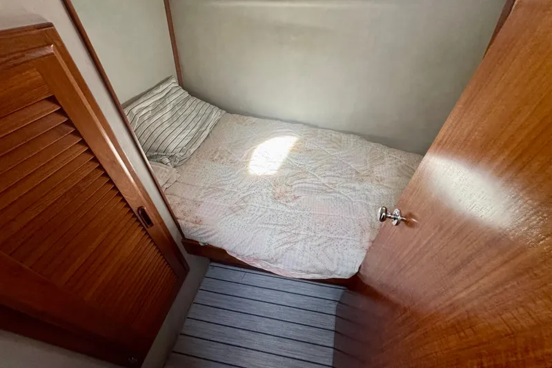 Slide: The Image of Cozy cabin bed in 1989 Mediterranean 38 yacht with wooden accents and striped pillow. - 14