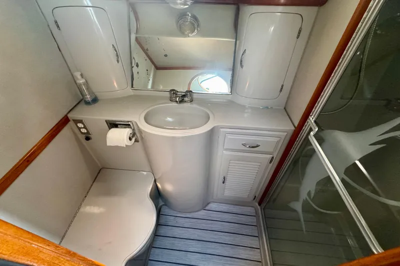 Slide: The Image of Compact bathroom in a 1989 Mediterranean 38 yacht, featuring sink, mirror, and shower. - 16