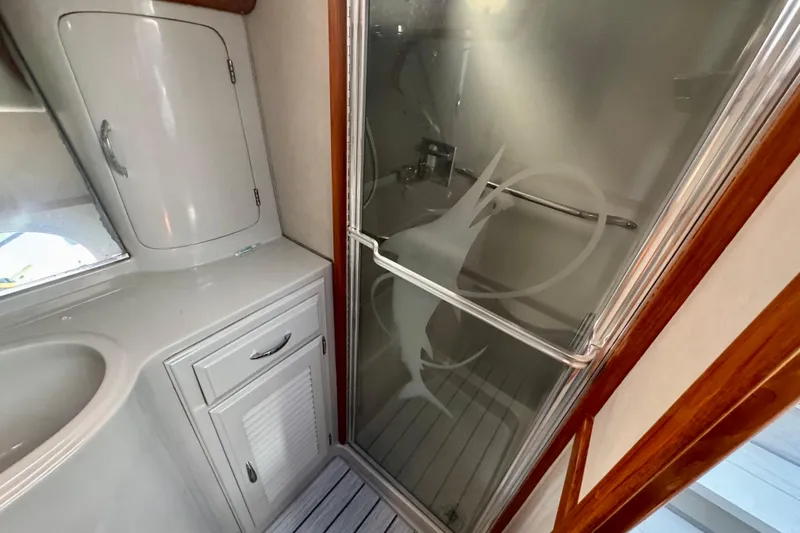 Slide: The Image of 1989 Mediterranean 38 yacht bathroom with frosted glass shower and white cabinetry. - 17
