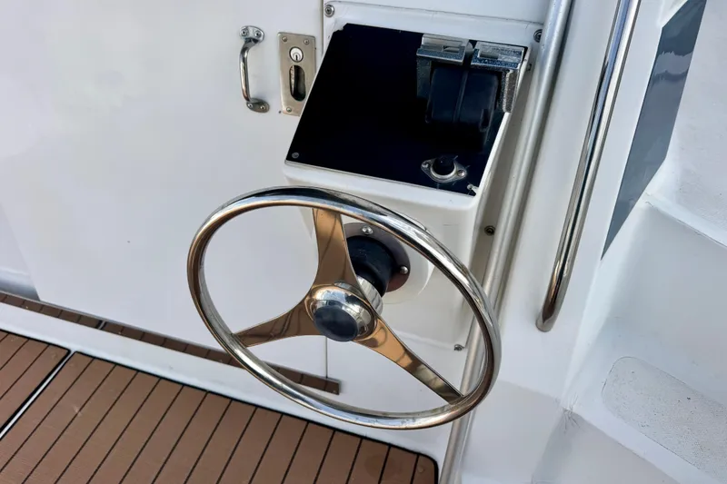 Slide: The Image of Steering wheel of a 1989 Mediterranean 38 boat, featuring a sleek metal design. - 8