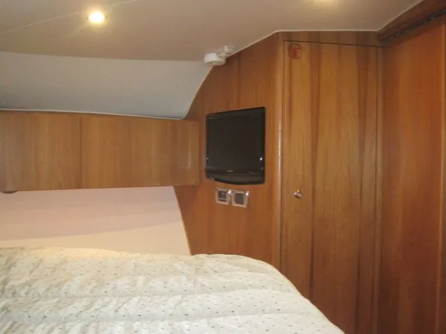 Slide: The Image of Interior of 2012 Tiara Yachts 3900 Open with wood paneling and bed. - 27