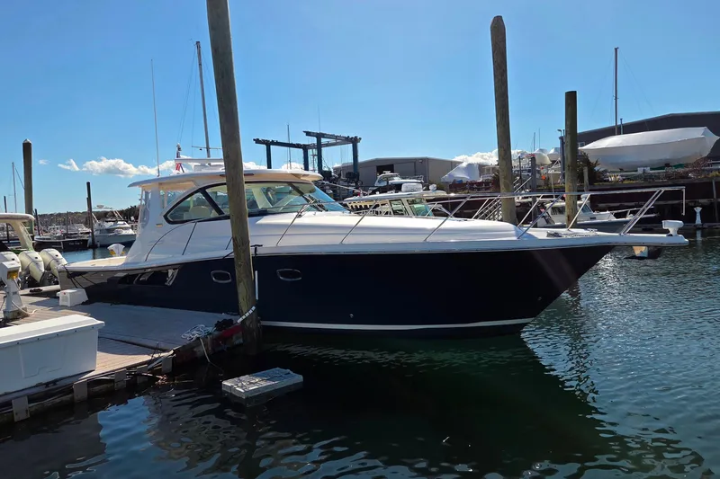 Slide: The Image of 2012 Tiara Yachts 3900 Open docked at marina under clear blue sky. - 3